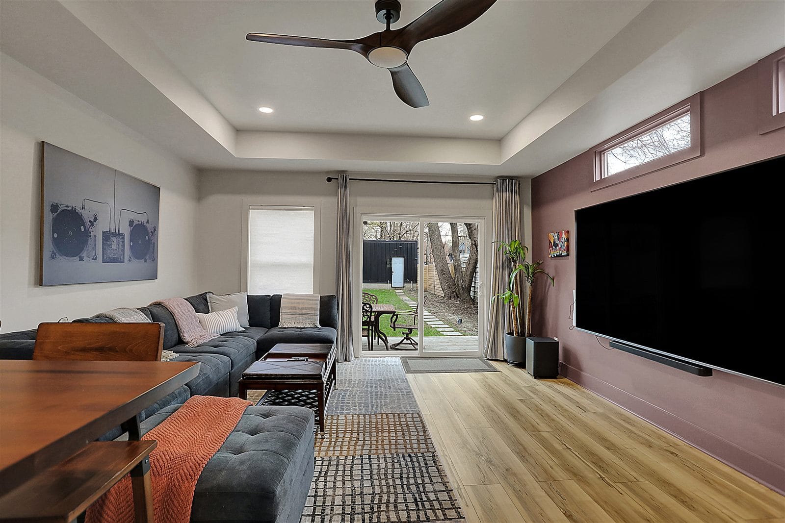 Upstairs loft landing with vaulted ceiling, art wall, reading chair, and cable rail stair