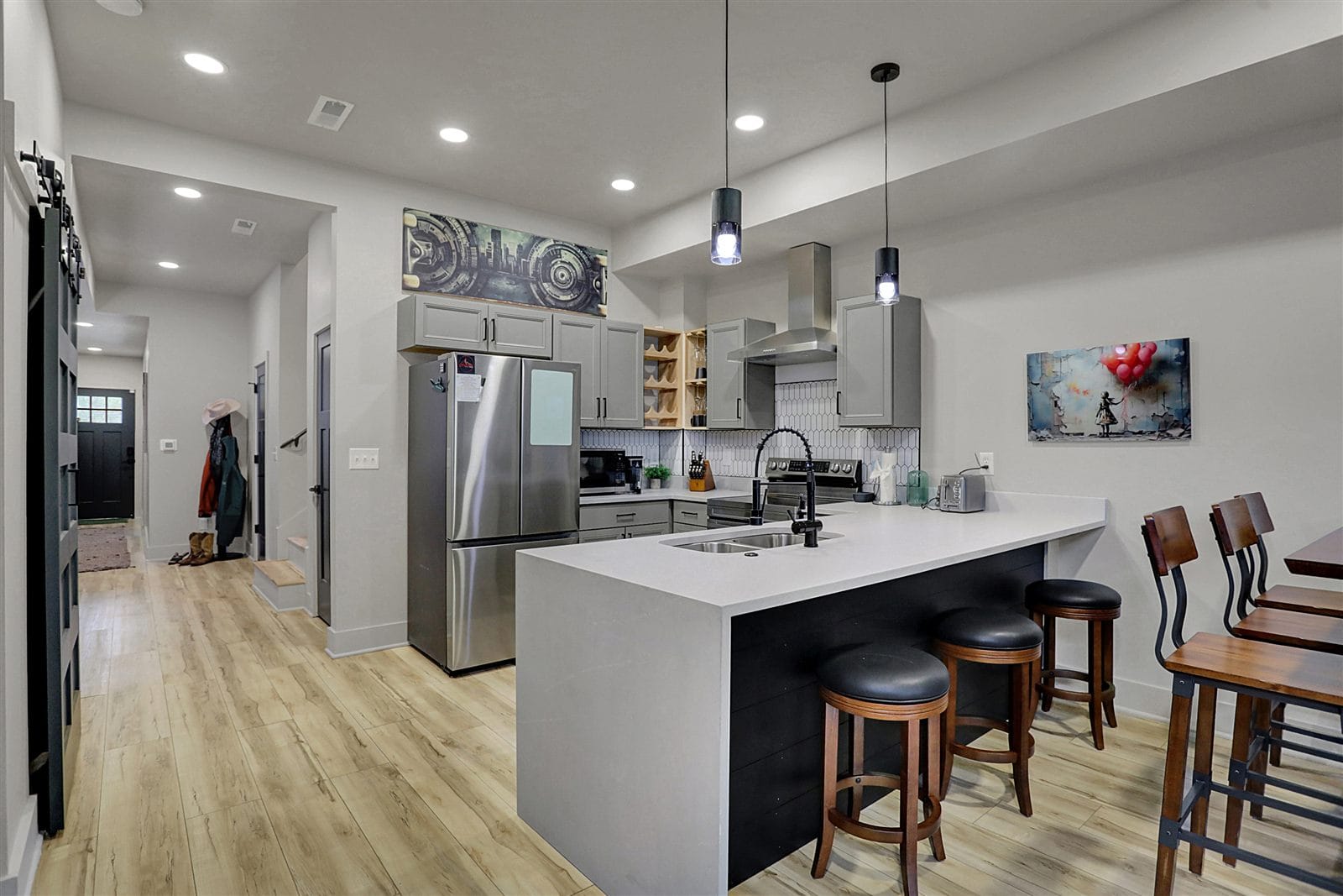 Living and dining area looking toward kitchen, with large wall TV, soundbar, and LVP floors