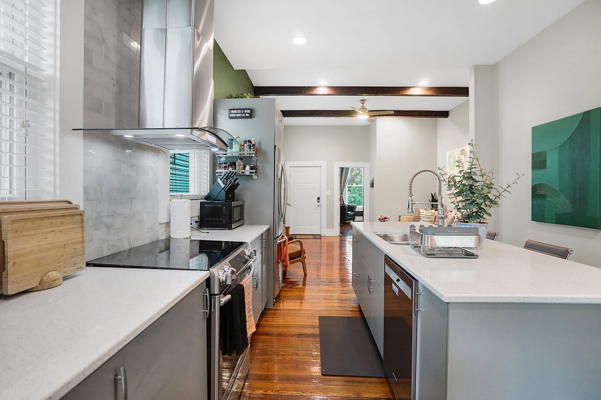 Full kitchen view with quartz counters, marble backsplash, professional hood, and multiple windows for natural light