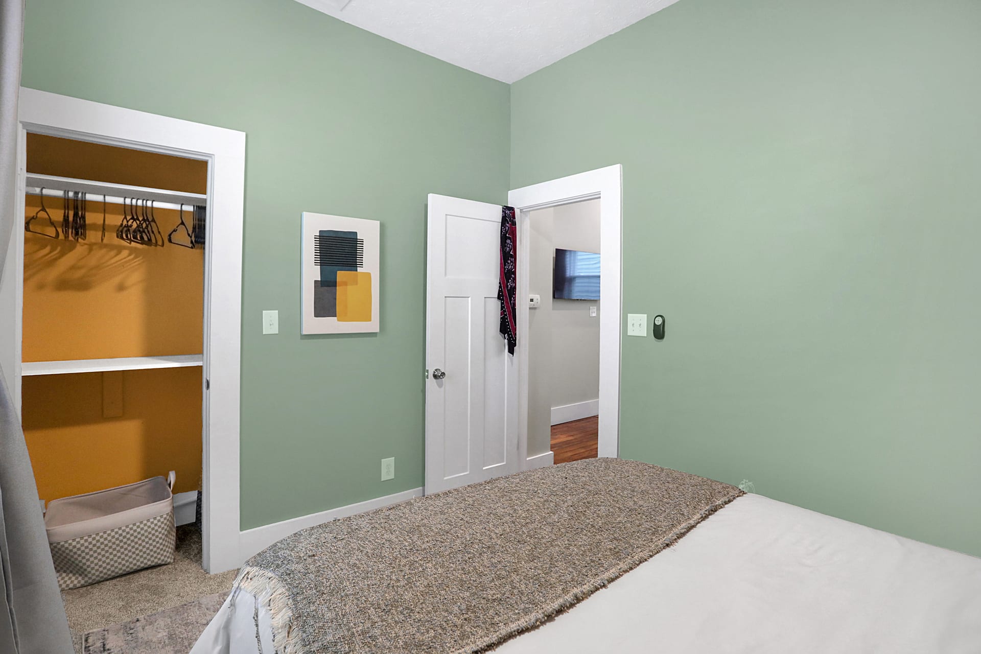 Third king bedroom with abstract art, ceiling fan, and tall windows overlooking the neighborhood