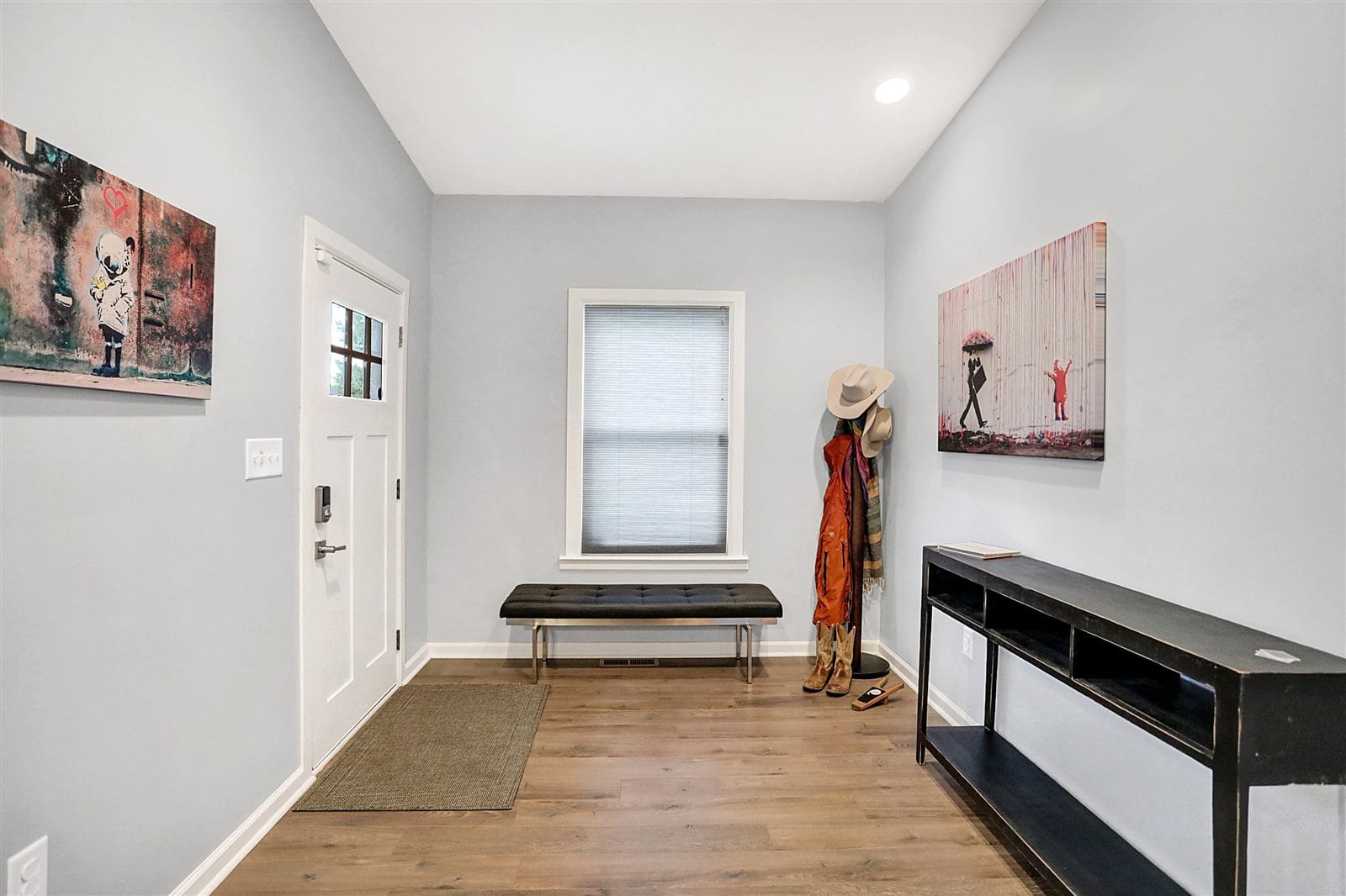 Open-plan living room looking toward kitchen with pendant lighting and hardwood floors